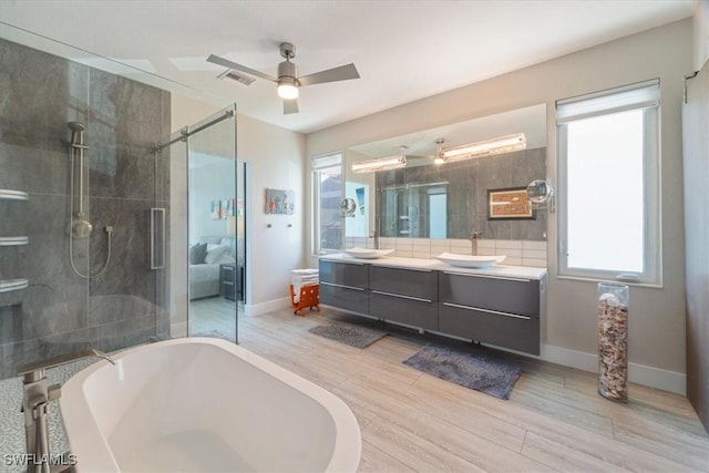 bathroom with separate shower and tub, a wealth of natural light, vanity, and hardwood / wood-style flooring