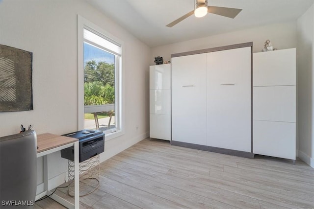 home office with ceiling fan, plenty of natural light, and light wood-type flooring