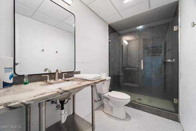 bathroom with a paneled ceiling, toilet, an enclosed shower, and sink