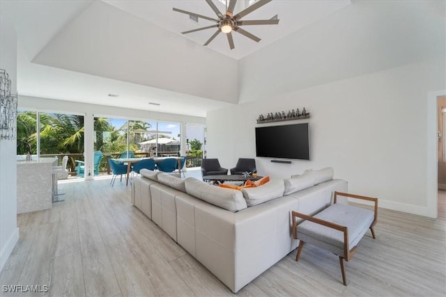 living room featuring ceiling fan, a healthy amount of sunlight, and light wood-type flooring