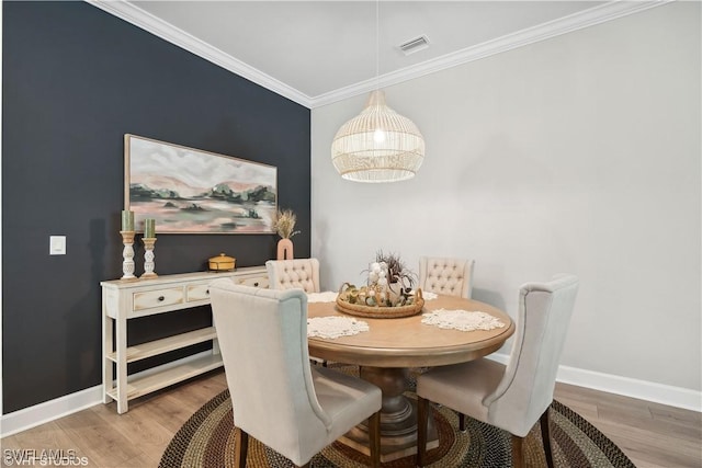 dining room with ornamental molding and hardwood / wood-style flooring