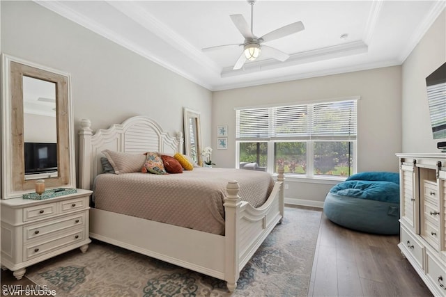 bedroom featuring ceiling fan, dark hardwood / wood-style floors, a raised ceiling, and crown molding