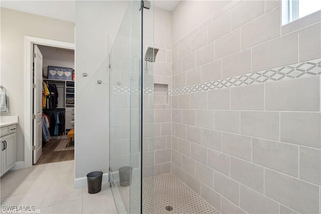 bathroom featuring tile patterned floors, vanity, and a tile shower