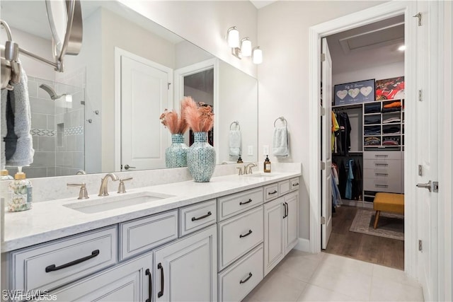 bathroom featuring tile patterned floors, vanity, and a tile shower