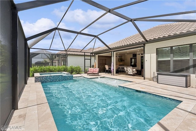 view of pool featuring outdoor lounge area, glass enclosure, ceiling fan, an in ground hot tub, and a patio