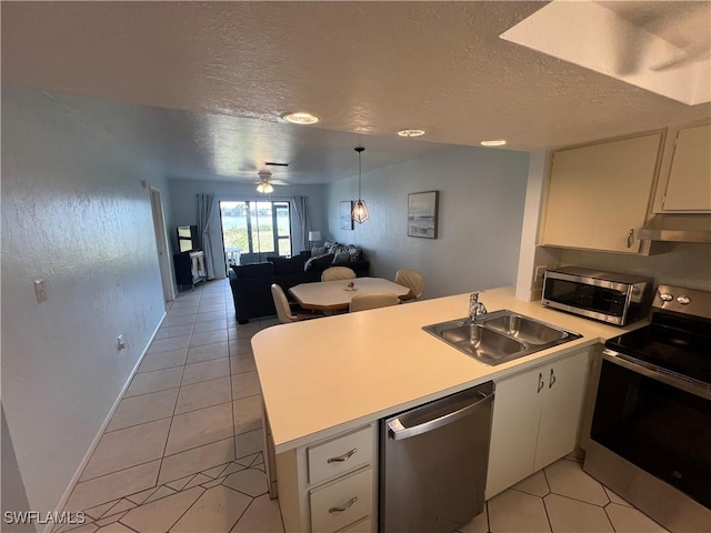 kitchen featuring ceiling fan, sink, kitchen peninsula, white cabinets, and appliances with stainless steel finishes