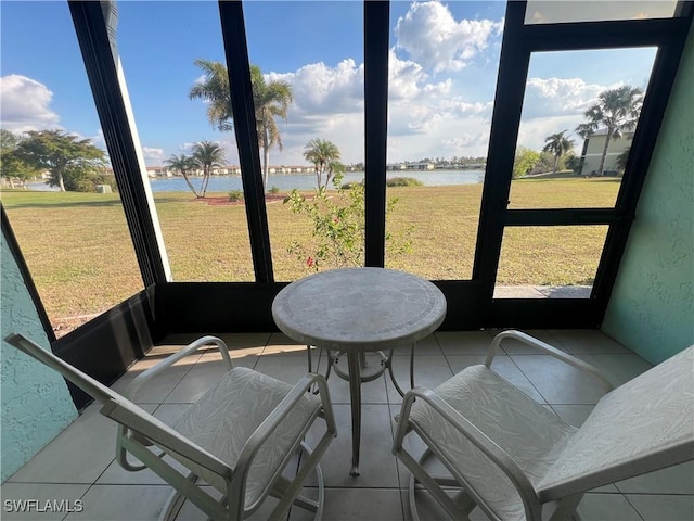 sunroom featuring a water view