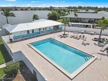 view of swimming pool with a water view and a patio area