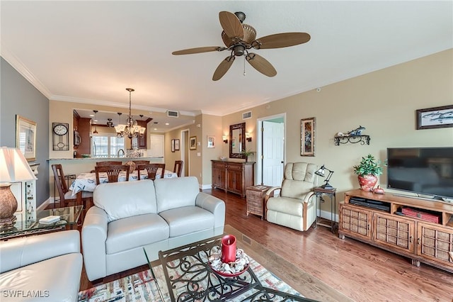 living room featuring ornamental molding, wood finished floors, visible vents, and baseboards