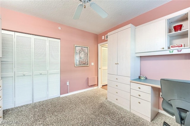 office area featuring baseboards, a ceiling fan, a textured ceiling, and light colored carpet