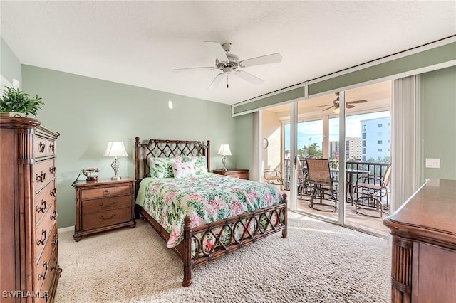 carpeted bedroom featuring a ceiling fan, access to exterior, expansive windows, a city view, and a textured ceiling