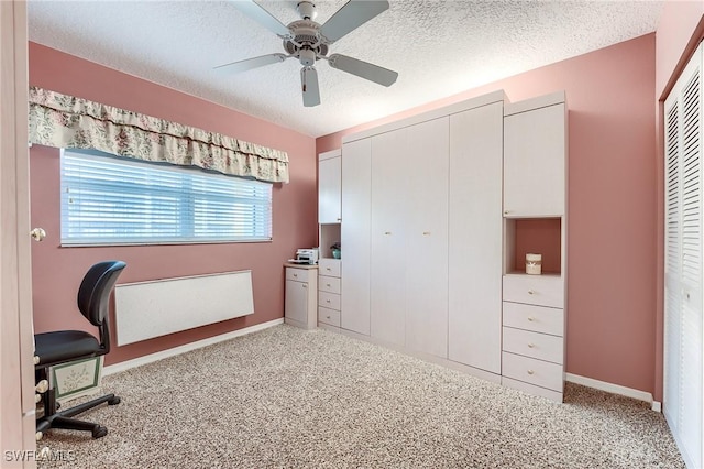 office featuring a ceiling fan, carpet flooring, a textured ceiling, and baseboards