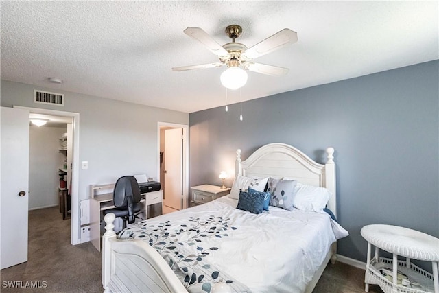 bedroom featuring dark colored carpet, ceiling fan, and a textured ceiling