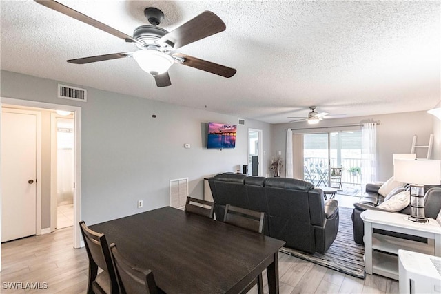 dining room featuring ceiling fan, a textured ceiling, and light hardwood / wood-style flooring