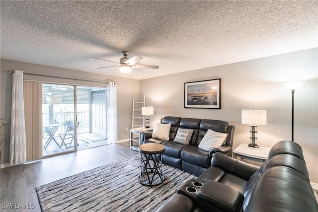 living room featuring ceiling fan, a textured ceiling, and hardwood / wood-style flooring