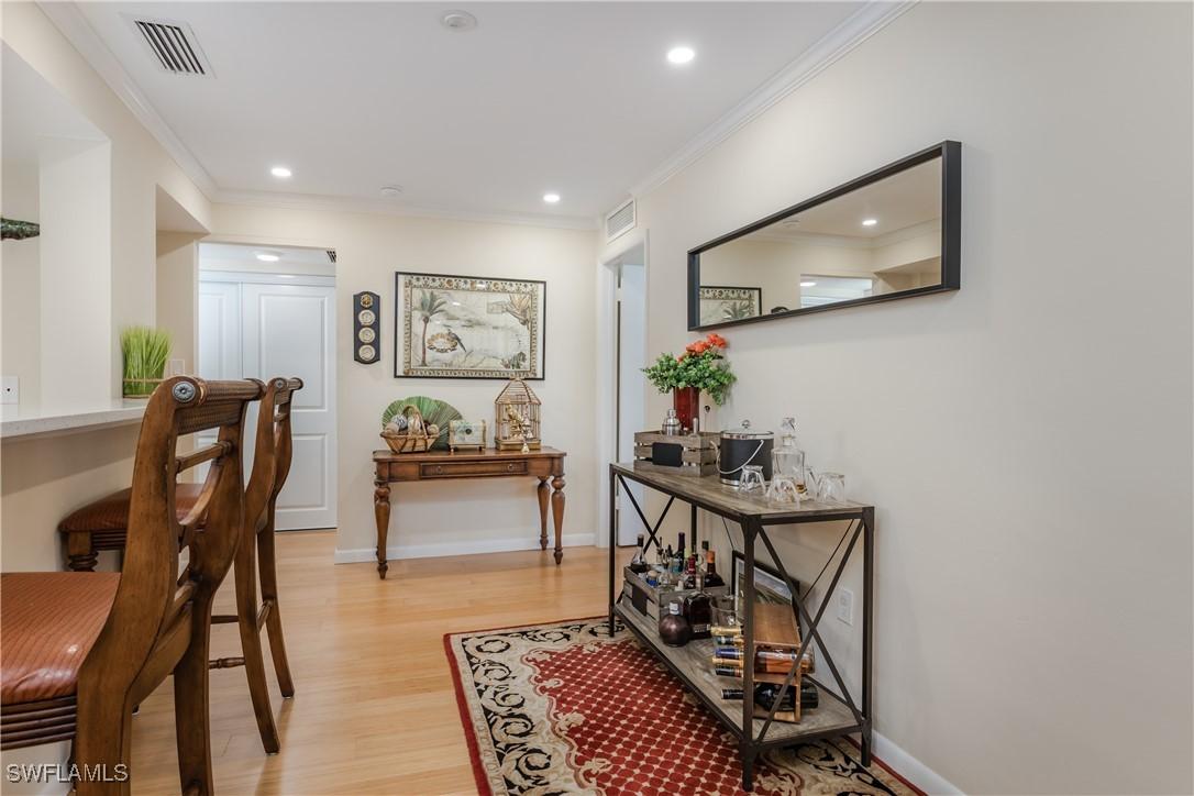 hallway featuring light hardwood / wood-style flooring and ornamental molding