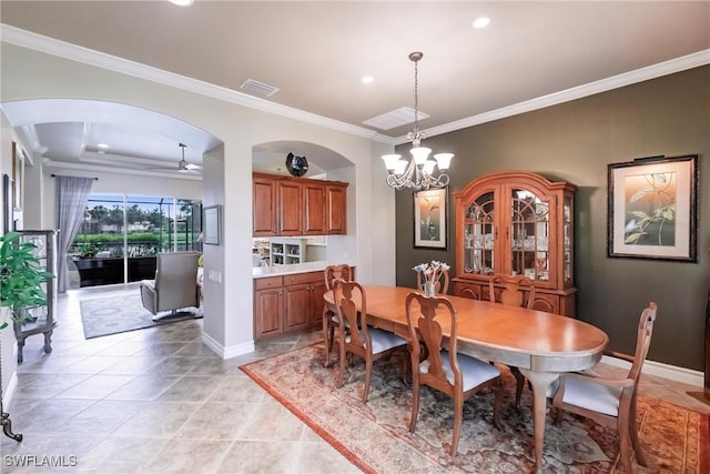 tiled dining space featuring crown molding and a chandelier