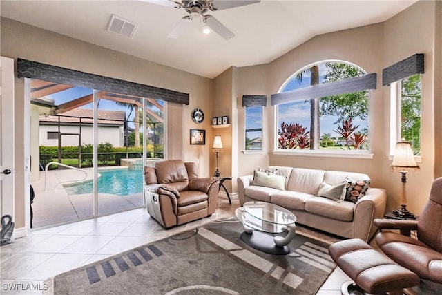 living room with ceiling fan, light tile patterned floors, and lofted ceiling