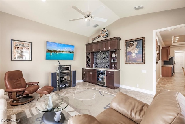 living room with bar area, ceiling fan, beverage cooler, and vaulted ceiling