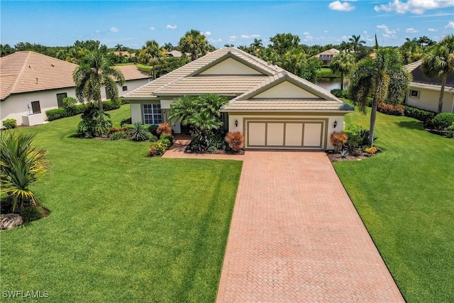 ranch-style house with a garage, a water view, and a front yard