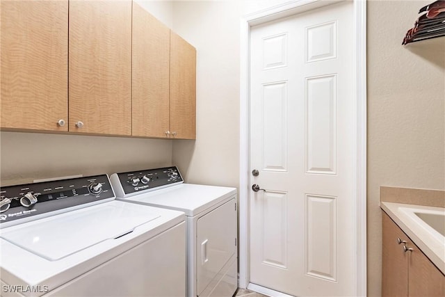 laundry area featuring washer and dryer and cabinets