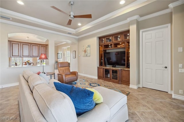 tiled living room featuring crown molding, ceiling fan, and a tray ceiling