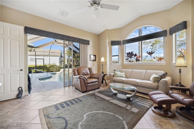 tiled living room with lofted ceiling, ceiling fan, and a healthy amount of sunlight