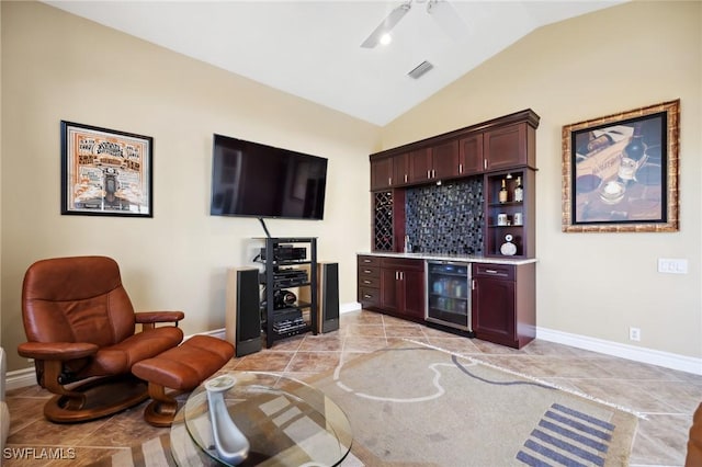 tiled living room featuring wine cooler, vaulted ceiling, ceiling fan, and indoor bar