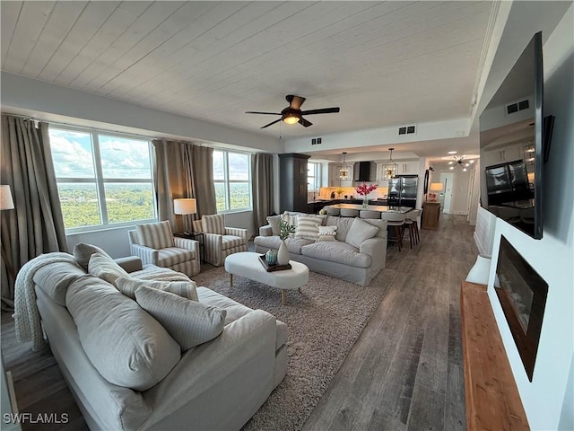 living room with dark hardwood / wood-style floors, a fireplace, ceiling fan, and wood ceiling