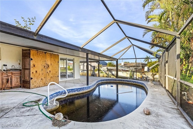 view of swimming pool with glass enclosure and a patio