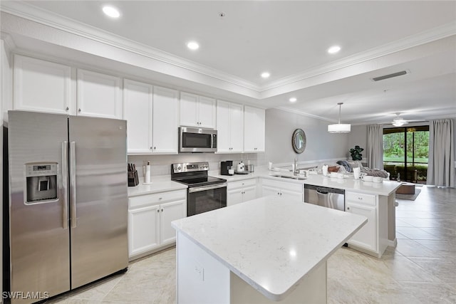 kitchen with decorative light fixtures, appliances with stainless steel finishes, kitchen peninsula, a kitchen island, and ceiling fan