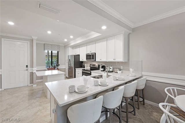 9590 Trevi Ct Unit 5314, Naples, FL 34113 - kitchen with stainless steel appliances, crown molding, a center island, a sink, and a peninsula