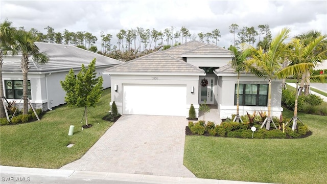 12830 Hawkins Dr, Estero, FL 33928 - ranch-style home with a garage, decorative driveway, a front yard, and stucco siding