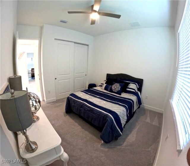 carpeted bedroom with ceiling fan and a closet