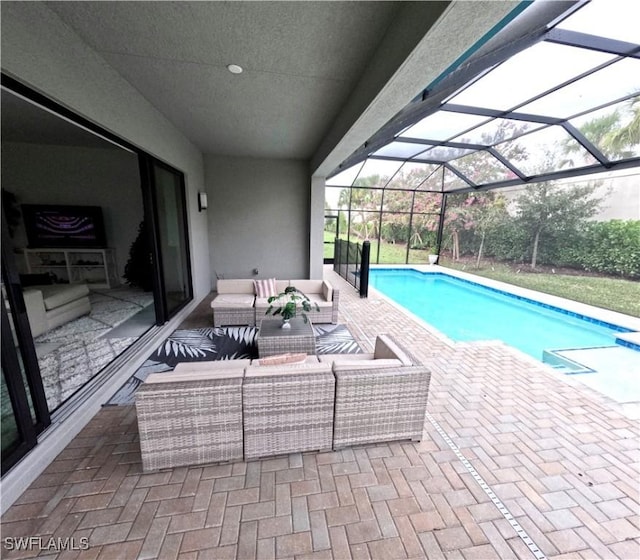 view of pool with an outdoor living space, a patio area, and glass enclosure