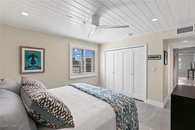 bedroom with a closet, ceiling fan, wooden ceiling, and light hardwood / wood-style floors