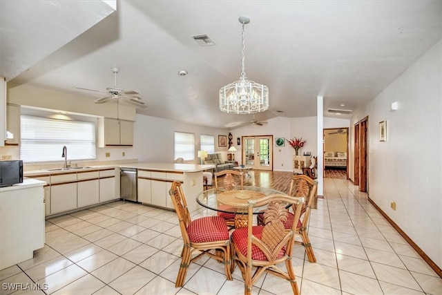 kitchen with pendant lighting, ceiling fan with notable chandelier, sink, vaulted ceiling, and kitchen peninsula