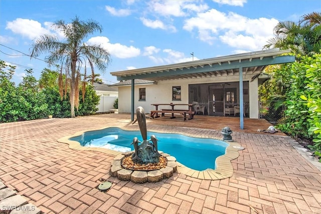 view of swimming pool featuring a patio area and a sunroom