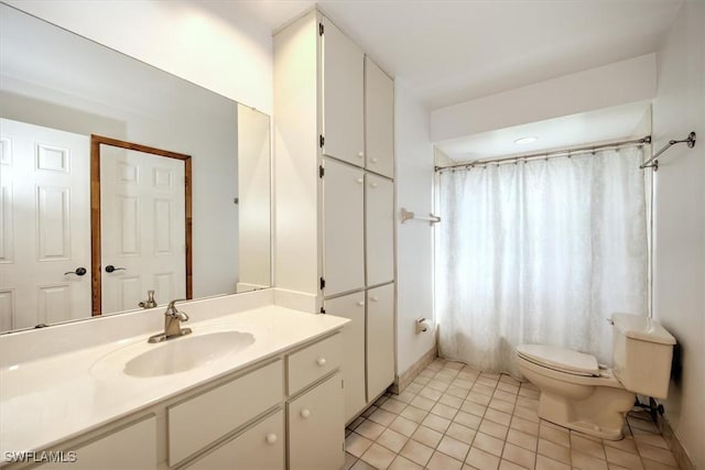 bathroom with toilet, vanity, and tile patterned floors