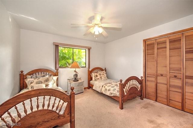 bedroom featuring ceiling fan, a closet, and light colored carpet