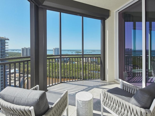 sunroom featuring a water view