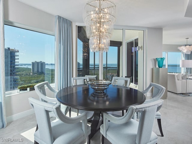 dining area featuring a water view and an inviting chandelier