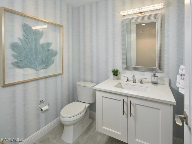 bathroom with toilet, vanity, and tile patterned floors