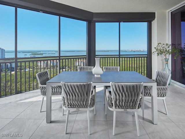 sunroom / solarium featuring a water view