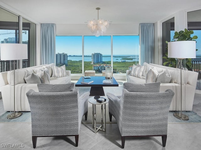 living room with a notable chandelier, plenty of natural light, a water view, and light tile patterned floors