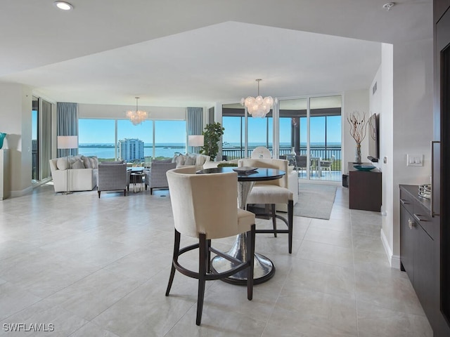 dining room with a notable chandelier, expansive windows, and a water view