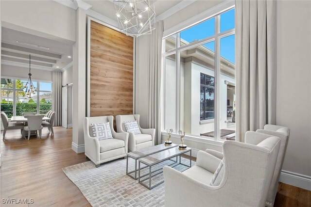 sitting room with hardwood / wood-style floors and a notable chandelier