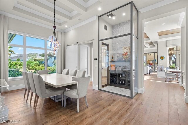 dining area with a barn door, crown molding, a high ceiling, and hardwood / wood-style flooring