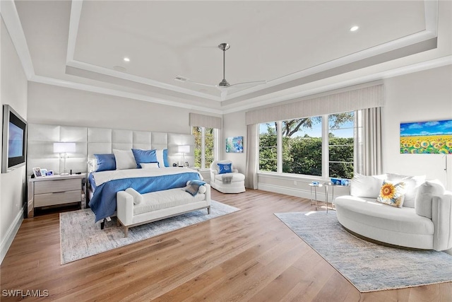 bedroom featuring a tray ceiling, ceiling fan, and light hardwood / wood-style floors