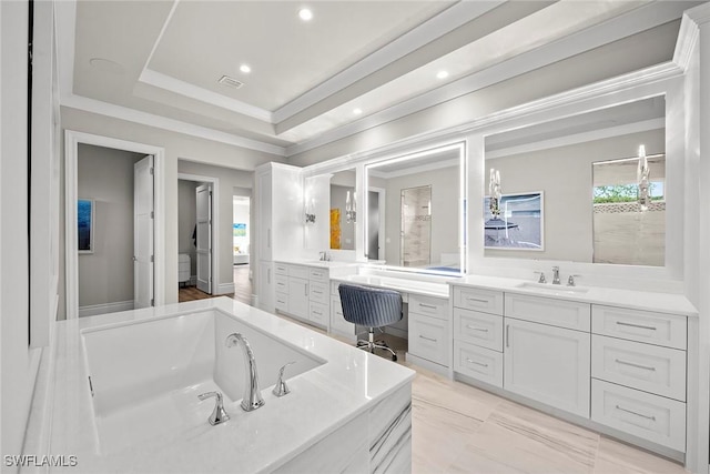 bathroom with vanity, a bathtub, and a tray ceiling